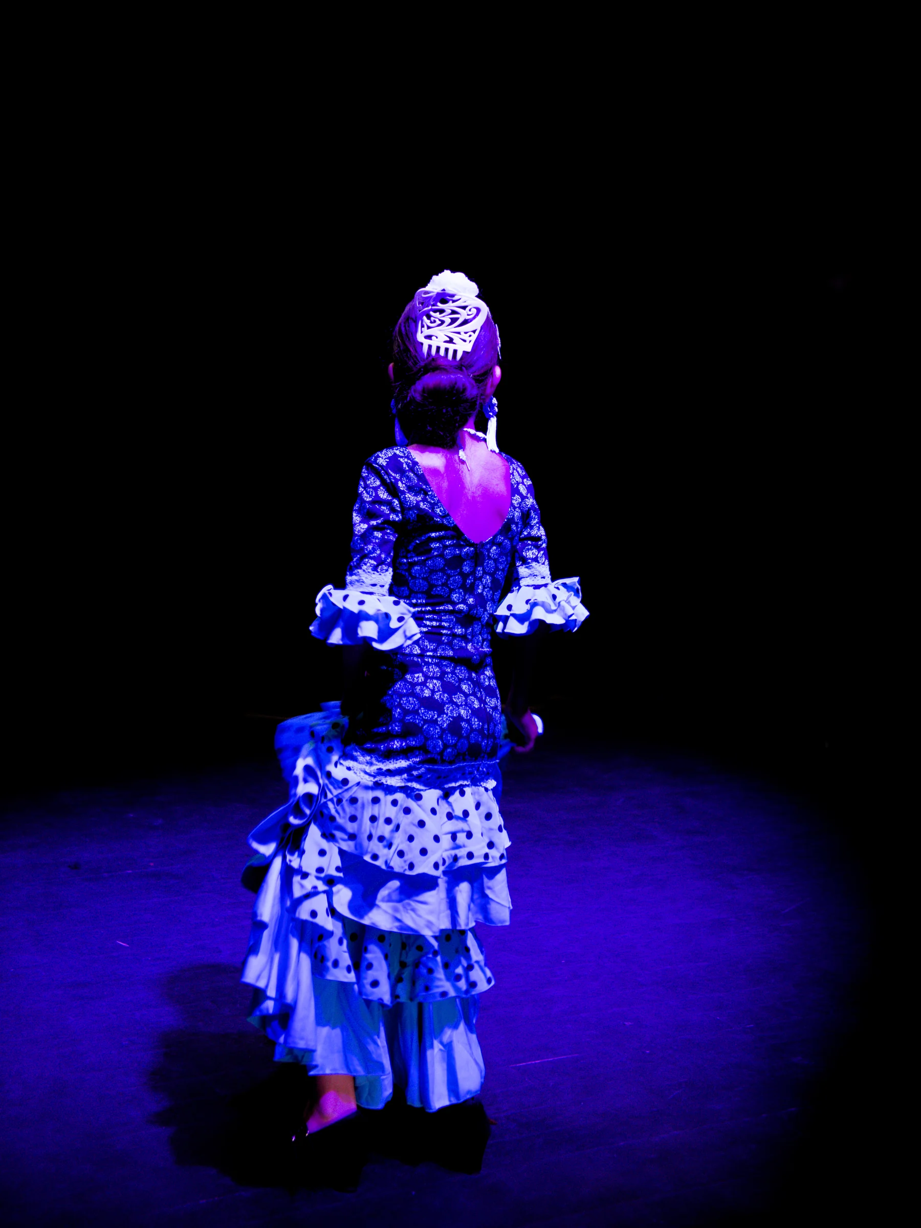 Danseuse flamenca avançant dans la lumière de la scène